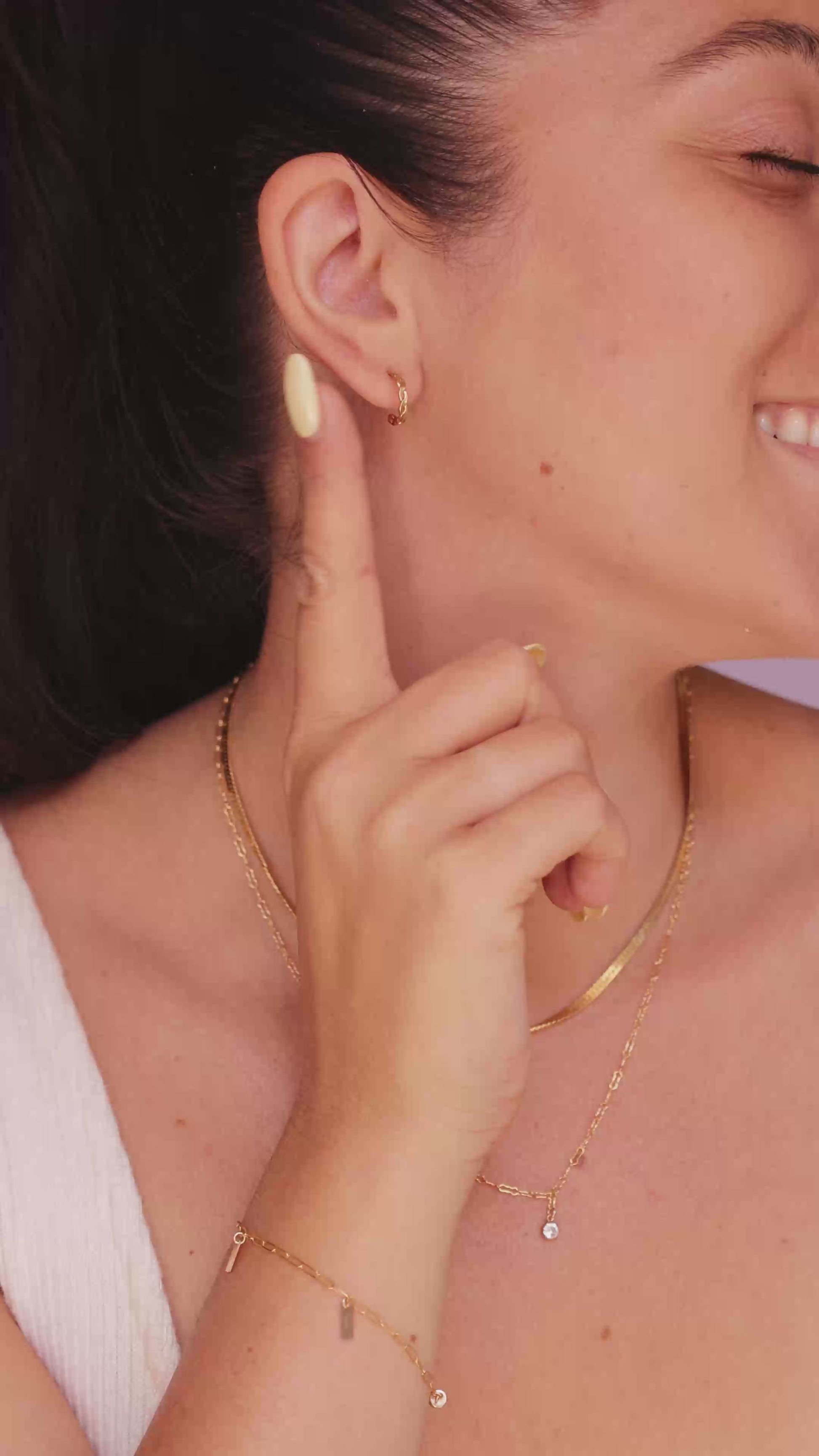 Model wearing the LucyKitty Gold Filled Twisted Hoop Earrings, Mira Herringbone Necklace, and Fayette Birthstone Necklace in April Diamond