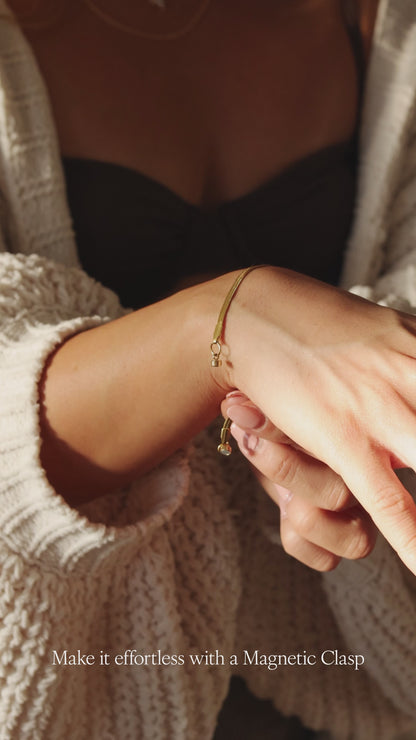 Model Clasping a LucyKitty Gold Filled Mira Fine Herringbone Bracelet